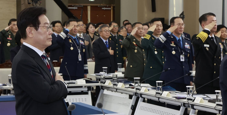이재명 대통령이 18일 서울 용산구 국방부에서 열린 국방부·국가보훈부 업무보고에서 국민의례를 하고 있다. 이날 업무보고에는 진영승 합동참모의장, 김규하 육군참모총장, 강동길 해군참모총장, 손석락 공군참모총장, 주일석 해병대사령관 등이 참석했다. / 뉴시스