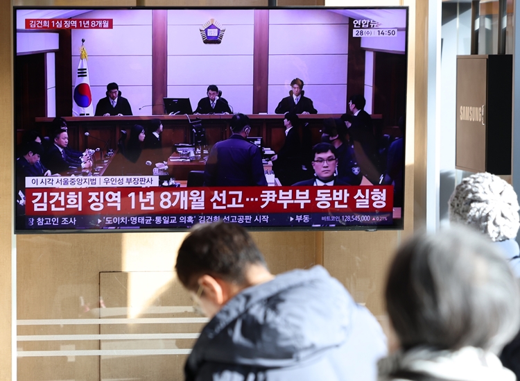 통일교 측으로부터 금품을 수수한 혐의로 1심에서 징역 1년 8개월을 선고받은 김건희 씨가 2일 법원에 항소했다. 사진은 지난달 28일 오후 서울 용산구 서울역에서 시민들이 김씨 1심 선고 공판 중계를 시청하고 있는 모습. / 뉴시스