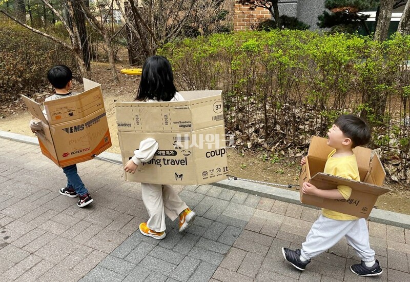 박스로 만든 기차를 타고 놀이터로 향하는 아이들. / 권정두 기자