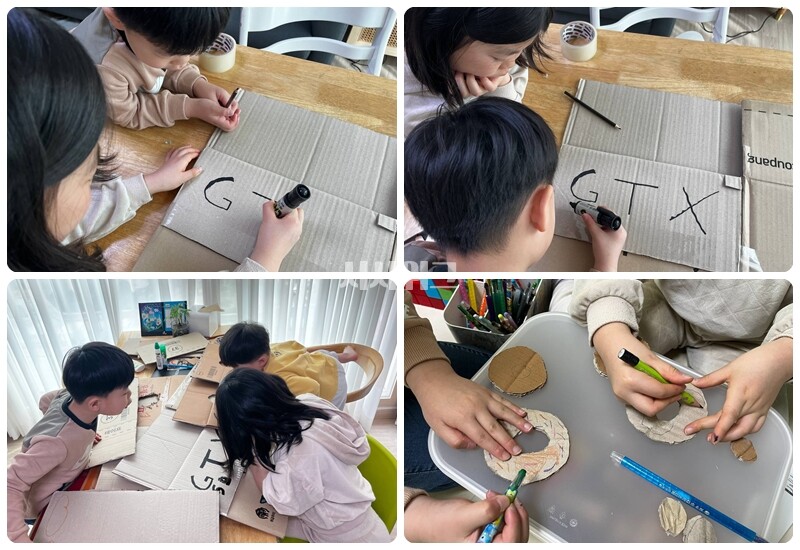 각자 기차 이름과 번호를 쓰고, 간단히 꾸며보기도 한다. 구멍을 내고 남은 박스 조각으로는 도넛 가게 놀이가 시작됐다. / 권정두 기자