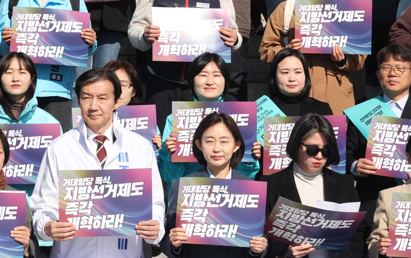 조국(앞줄 왼쪽부터) 조국혁신당 대표, 김재연 진보당 상임대표, 용혜인 기본소득당 대표가 19일 오전 서울 여의도 국회 본청 계단에서 열린 시민사회-제정당 정치개혁 관련 기자회견에서 손피켓을 들고 있다. / 뉴시스