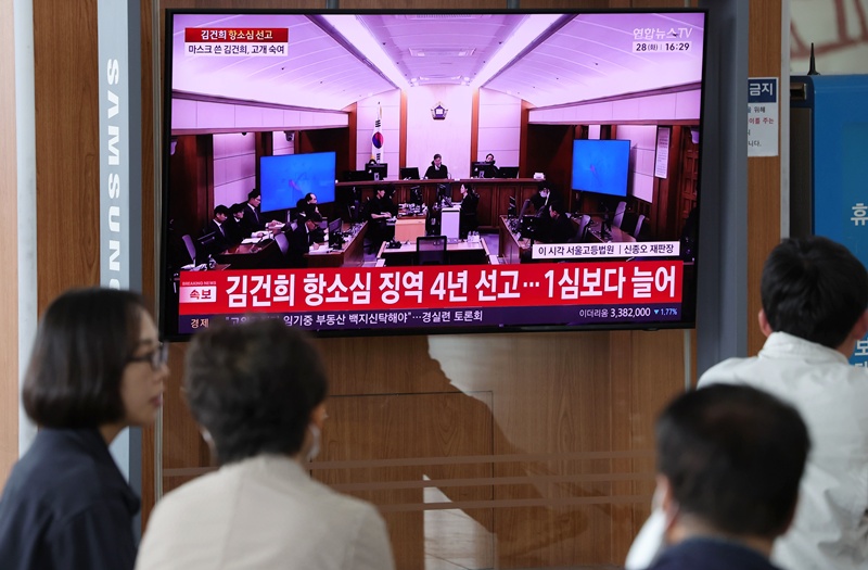 28일 오후 서울 중구 서울역 대합실에서 시민들이 김건희 여사의 도이치모터스 주가조작, 무상여론조사 수수, 통일교 금품 수수 혐의 관련 항소심 선고 생중계를 지켜보고 있다. / 뉴시스