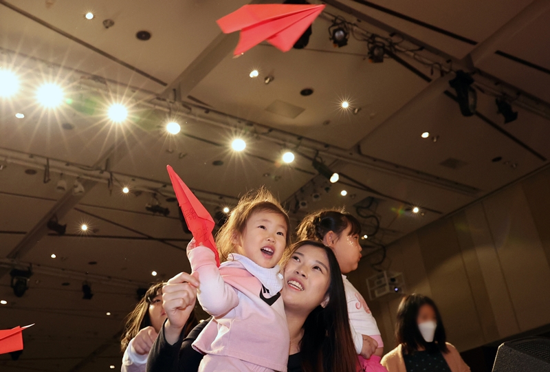 국회에선 한부모 가정의 경제적 지원을 위한 법이 추진되고 있다. 사진은 지난 2023년 11월 21일 서울 영등포구 63컨벤션센터에서 열린 제2회 한부모가족 축제에서 한 아이와 어머니가 소원을 적은 비행기를 날리고 있는 모습. / 뉴시스