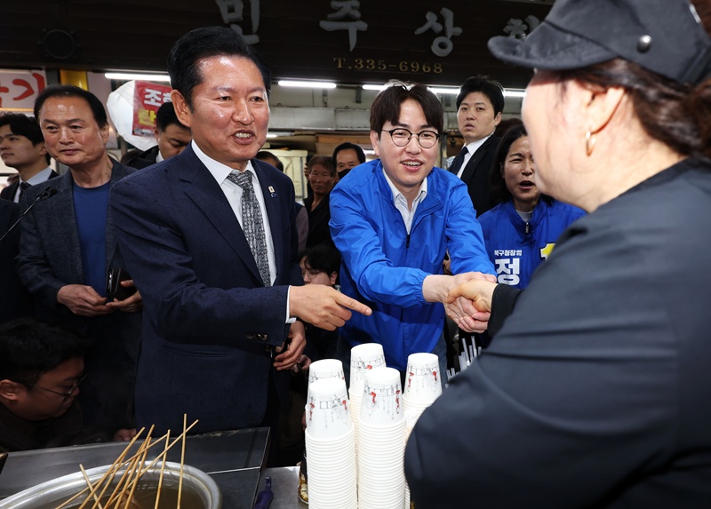 정청래 더불어민주당 대표가 지난 3일 부산 북구 구포시장에서 하정우 전 청와대 AI미래기획수석 등과 상인들에게 인사하며 지지를 호소하고 있는 모습이다. / 뉴시스