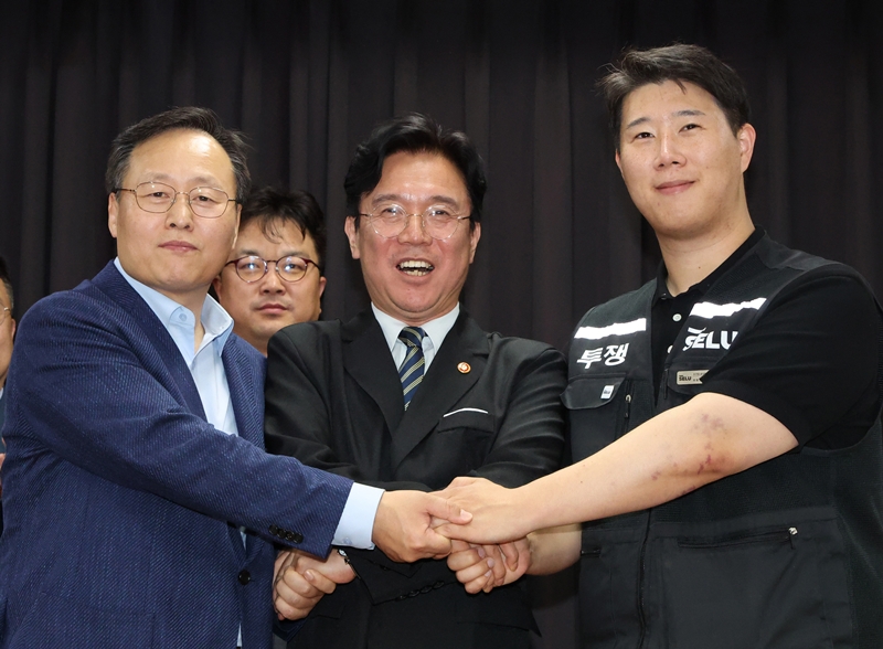 20일 경기 수원시 장안구 경기고용노동청에서 열린 삼성전자 임금협상을 마친 후 여명구 삼성전자 DS(디바이스솔루션·반도체 사업 담당) 피플팀장(왼쪽부터)과 김영훈 고용노동부 장관, 최승호 삼성그룹 초기업노동조합 삼성전자지부 위원장이 잠정 합의한에 서명한 후 손을 맞잡고 파이팅을 외치고 있다. (공동취재) / 뉴시스