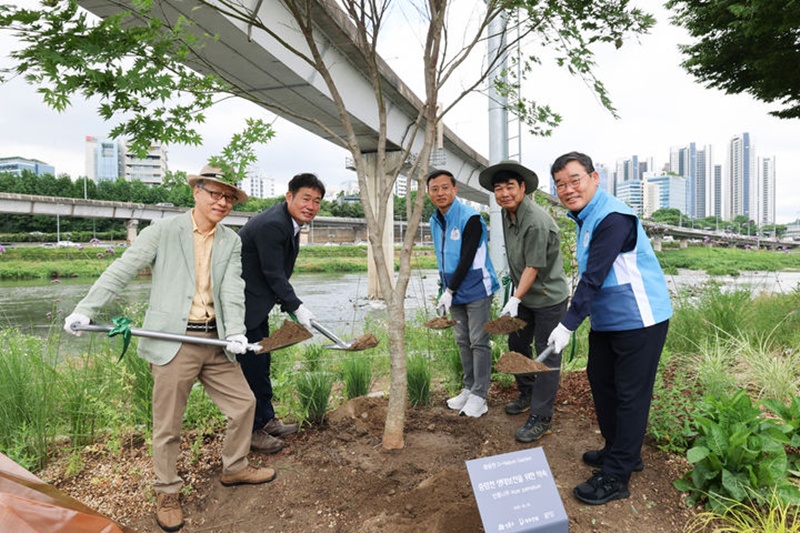 성동구 고광현 부구청장(왼쪽에서 두번째), 대우건설 김보현 대표이사(오른쪽에서 첫번째)를 포함한 참석자들이 단풍나무 식수 활동을 진행하고 있다. / 대우건설