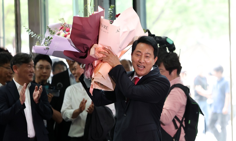 오세훈 서울시장은 현 사태와 관련해 선거관리위원회의 관리 부실을 규탄하면서도 “(장동혁 대표가) 언제 당의 총의를 모은 적이 있냐”며 “본인이 대표로서 하는 얘기니까 (정치적) 구호로서 기능한다고 보면 된다”고 거리를 뒀다. 사진은 지난 4일 오세훈 시장이 서울시청으로 들어서며 직원들에게 받은 꽃다발을 들고 기뻐하는 모습. / 뉴시스