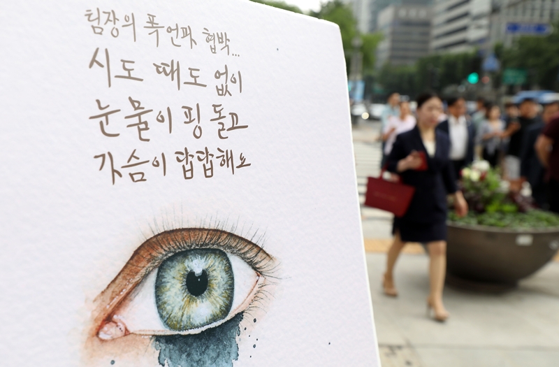2019년 7월 16일 오전 서울 종로구 광화문 광장 네거리에서 열린 갑질금지법 시행 맞이 캠페인에 설치된 판넬 앞을 시민들이 지나고 있다. / 뉴시스