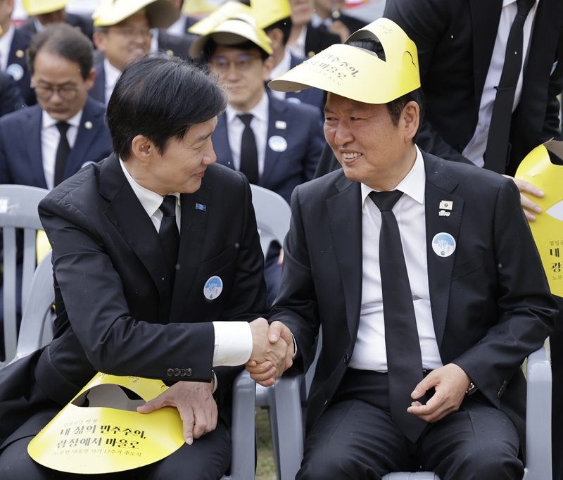 정청래 더불어민주당 대표와 조국 조국혁신당 대표가 지난 5월 23일 경남 김해시 봉하마을에서 열린 노무현 전 대통령 서거 17주기 추도식에 참석해 인사를 나누고 있다. / 뉴시스