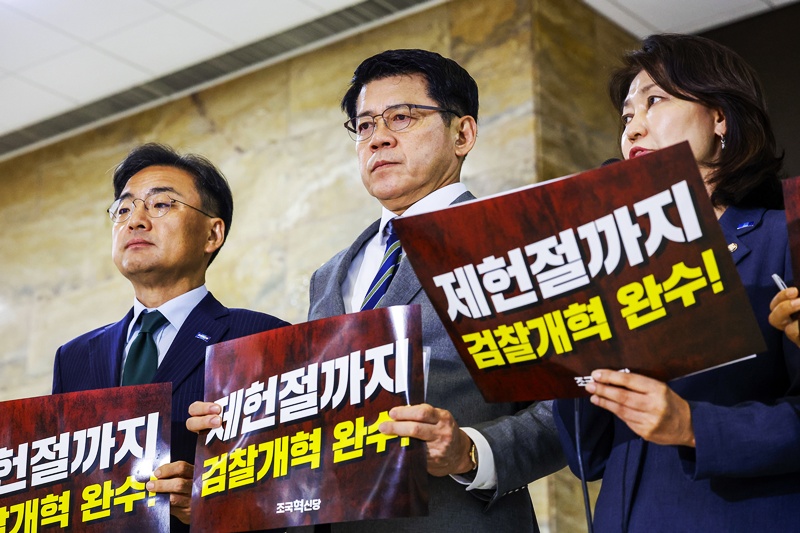신장식 조국혁신당 대표 권한대행과 김준형 원내대표를 비롯한 소속 의원들이 30일 서울 여의도 국회 로텐더홀에서 열린 조국혁신당 의원총회에서 검찰개혁 관련 피켓을 들고 있다. / 뉴시스