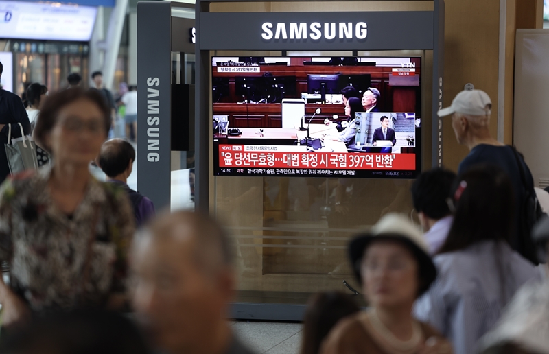 지난 2022년, 제20대 대선 당시 허위사실을 공표한 혐의로 기소된 윤석열 전 대통령이 1심에서 징역형의 집행유예를 선고받은 가운데, 여야가 이를 두고 공방을 주고받았다. 사진은 윤 전 대통령 1심 선고 공판이 열린 27일 서울역에서 시민들이 관련 방송을 지켜보고 있는 모습. / 뉴시스