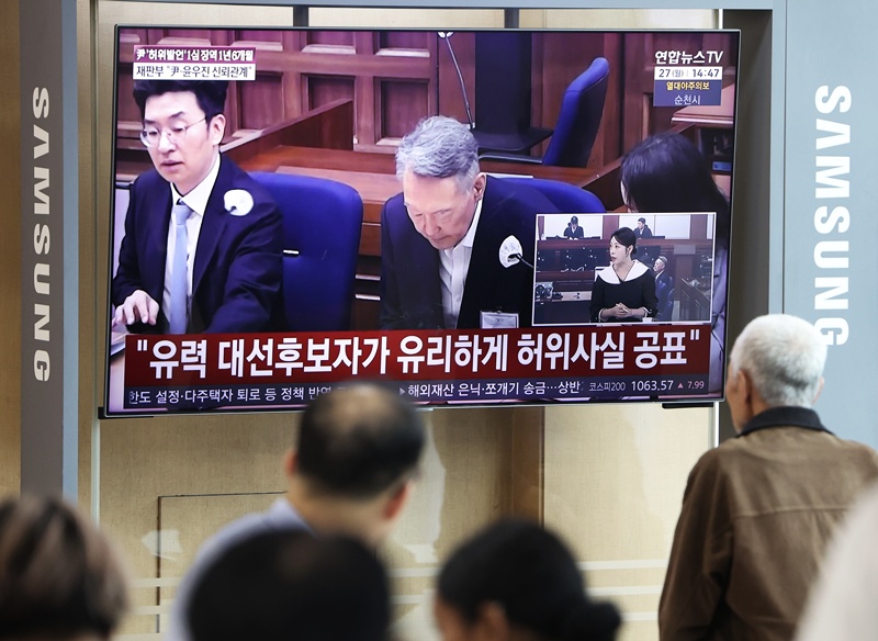 대선후보 시절 건진법사 전성배 씨에 관한 허위사실을 공표한 혐의로 기소된 윤석열 전 대통령 1심 선고 공판이 열린 27일 서울역에서 시민들이 관련 방송을 지켜보고 있다. 이날 재판부는 윤 전 대통령에게 징역 1년 6개월에 집행유예 3년을 선고했다. / 뉴시스