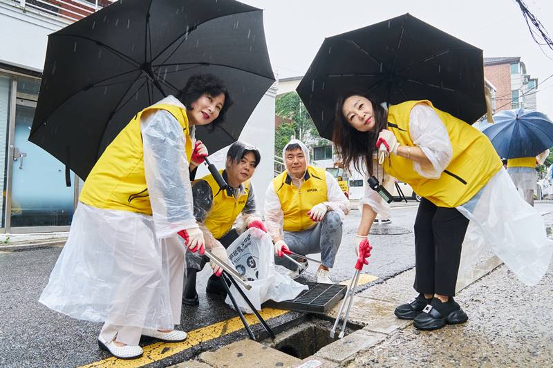  IPARK현대산업개발은 교육·환경·주거 분야를 아우르는 다양한 사회공헌 활동을 통해 지역사회와 함께 성장하는 ESG 경영을 실천하고 있다. 사진은 IPARK현대산업개발이 장마철을 맞아 서울 용산구 갈월동 일대에서 집중호우에 대비한 빗물받이 청소 봉사활동을 진행하는 모습. / IPARK현대산업개발