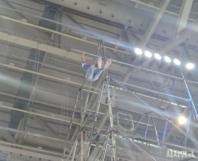 민주당 당원으로 전해진 한 남성이 행사가 시작되자 고층 구조물에 난입해 구조물을 흔드는 등 소동을 벌였다. / 사진=김소은 기자
