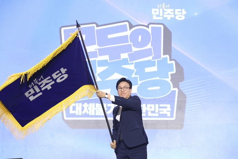 김민석 신임 더불어민주당 당대표가 지난 17일 대전 유성구 대전컨벤션센터 제2전시장에서 열린 더불어민주당 제3차 정기전국당원대회에서 당기를 흔들고 있다. (공동취재) / 뉴시스