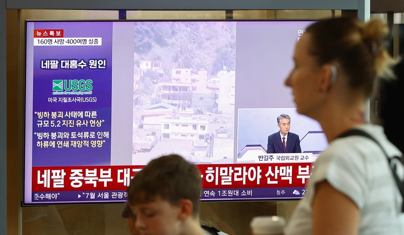 27일 서울역 대합실에서 승객들이 네팔 대홍수 관련 보도를 시청하고 있다. / 뉴시스