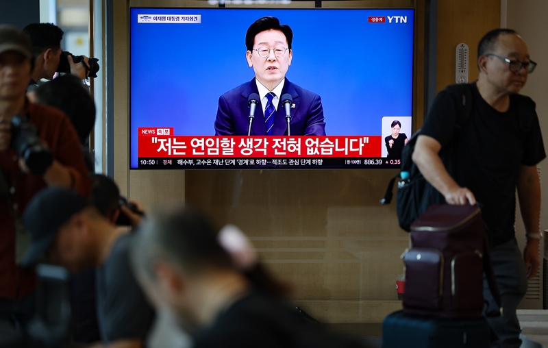 18일 서울 용산구 서울역 대합실에서 시민들이 TV를 통해 이재명 대통령의 기자회견을 지켜보고 있다. / 뉴시스
