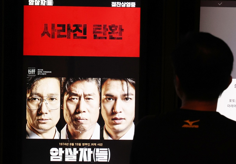 영화 ‘암살자(들)’의 역사 해석을 둘러싼 논란이 상영 중단 요구와 5·18 관련 법률 폐지 주장으로 번졌다. 영화의 표현을 따지는 논쟁이 진영 간 공방으로 확대되고 있다는 비판도 나온다. 사진은 29일 서울의 한 영화관 예매 키오스크에 '암살자(들)'이 나오고 있는 모습이다. / 뉴시스