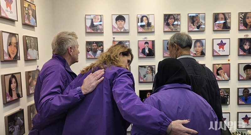 이태원참사 기억소통공간 '별들의집' 내부 한 켠에 마련된 희생자들의 사진을 바라보고 있는 외국인 유가족들의 모습이다. / 이민지 기자